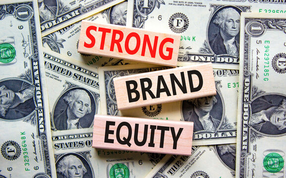 Strong brand equity symbol. Concept words Strong brand equity on wooden blocks on a beautiful background from dollar bills. Business, finacial and strong brand equity concept.