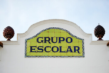 Grupo escolar, colegio, escuela primaria. Rótulo de azulejos de grupo escolar con fondo verde. Mosaico con letrero de cerámica vidriada.