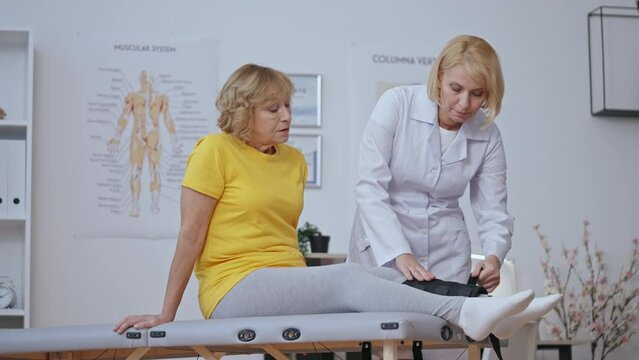 Traumatologist putting on cast to patient's leg, bone fracture treatment plan