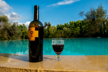 butelka doskonałego czerwonego wina, deystacja na basenie