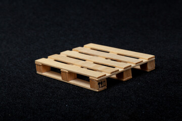 Reduced model wooden euro pallet on black felt background....