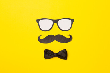 Glasses, mustache and bow tie on color background, top view. Happy Father's Day concept