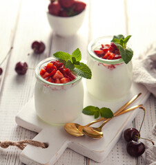 jars of yogurt with berries on the white wooden table