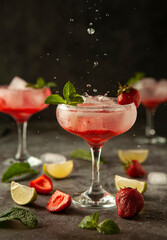 cocktail with strawberry and mint with drops in motion