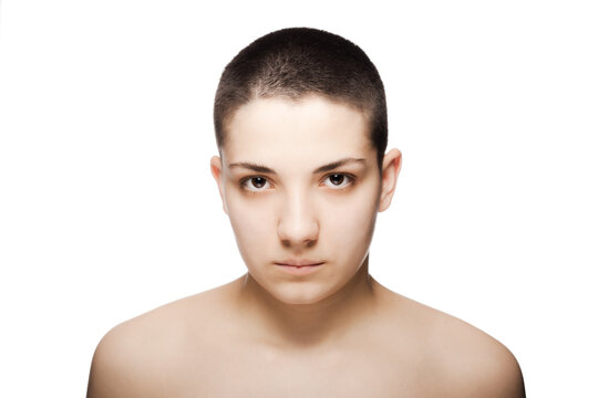 studio portrait of a beautiful young woman with very short hair against white backgroung.