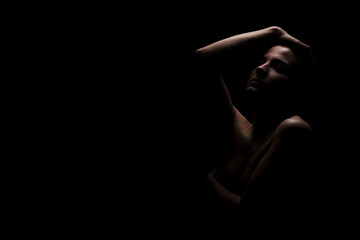 Obraz premium Portrait of a girl with short hair against dark background. Side lit contour slhouette...