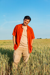Naklejka na ściany i meble Stylish man stand in wheat field in summer