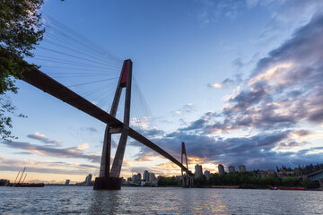 Obraz premium Skytrain and Pattullo Bridge in New Westminster and Surrey, Greater Vancouver, British Columbia, Canada. Sunset Sky. Brownsville Bar Park.