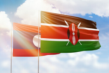 Sunny blue sky and flags of kenya and laos