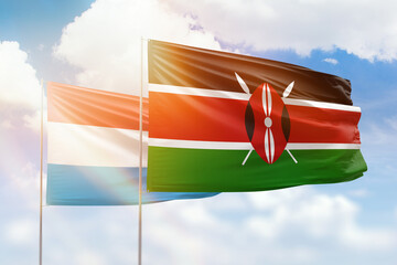 Sunny blue sky and flags of kenya and luxembourg