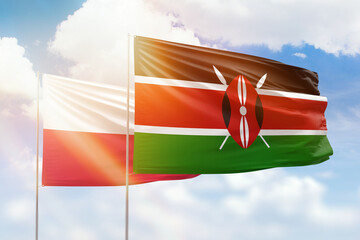 Sunny blue sky and flags of kenya and poland