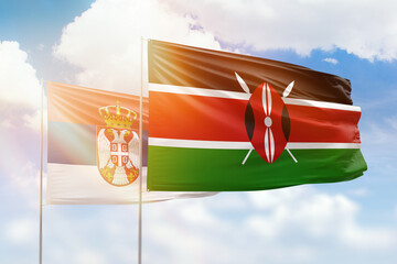 Sunny blue sky and flags of kenya and serbia