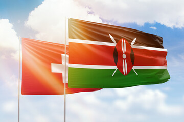 Sunny blue sky and flags of kenya and switzerland