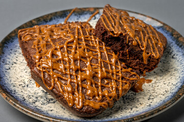 stone plate with three pieces of brownies with hazelnut butter with cocoa frosting