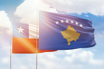Sunny blue sky and flags of kosovo and chile