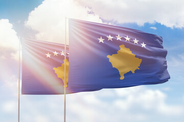 Sunny blue sky and flags of kosovo and kosovo