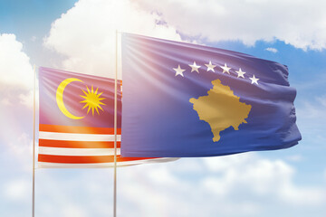 Sunny blue sky and flags of kosovo and malaysia