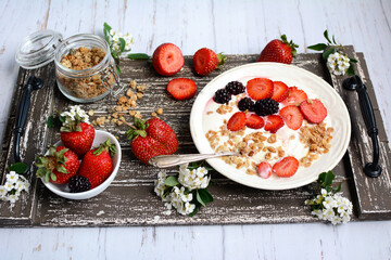 Healthy and nutritious breakfast. Muesli with strawberries and blackberries on a wooden tray