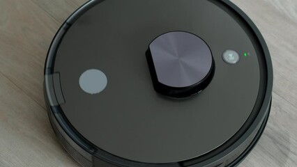 Robot vacuum cleaner vacuuming the floor in living room. Smart home with automated devices that simplify life. A smart vacuum cleaner cleans the floor. 