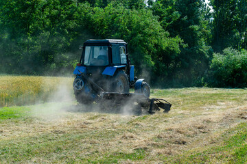 Fototapeta premium Road services landscaping around roads in tractor mows lawn grass with a mechanical mower mowing grass on the side of the asphalt road.A series of pictures.