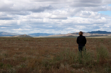 Beautiful mongolian landscape with an unrecognizable woman in black seen from her back
