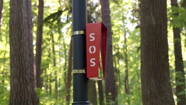 Red intercom in park for emergency communication,you have to press button for help in forest on pole.
