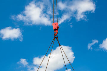 Crane hook and slings against the sky. Lifting cargo by crane