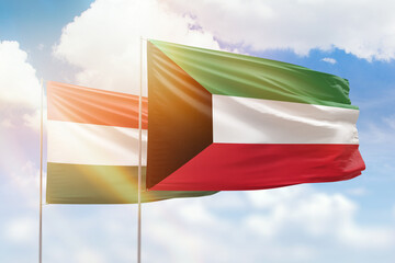 Sunny blue sky and flags of kuwait and hungary