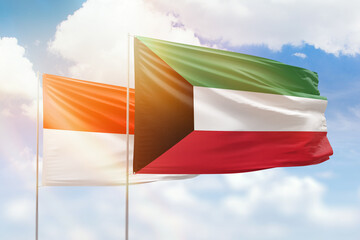 Sunny blue sky and flags of kuwait and indonesia