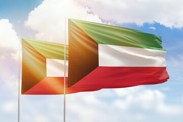 Sunny blue sky and flags of kuwait and kuwait