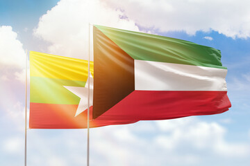 Sunny blue sky and flags of kuwait and myanmar