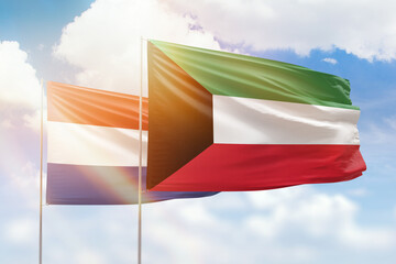 Sunny blue sky and flags of kuwait and netherlands