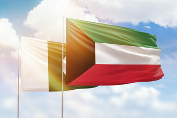 Sunny blue sky and flags of kuwait and pakistan