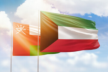 Sunny blue sky and flags of kuwait and oman