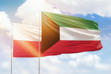 Sunny blue sky and flags of kuwait and poland