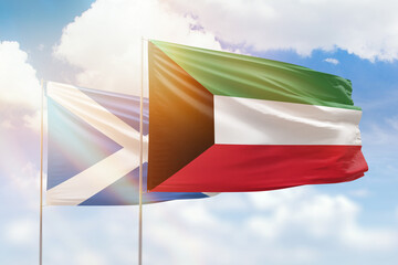 Sunny blue sky and flags of kuwait and scotland