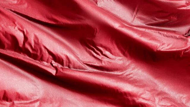 Red textile fabric waving on the wind background. Solid Color Tone. Full filling seamless loop.
