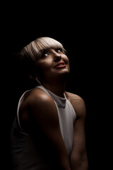 Fototapeta premium Beautiful girl with blond bangs fringe wearing white fashionable fancy dress against black background. .
