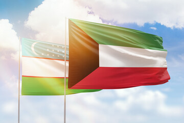 Sunny blue sky and flags of kuwait and uzbekistan