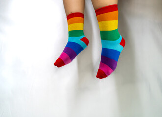 Legs in colorful rainbow socks against white background