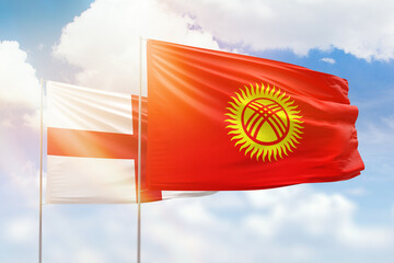 Sunny blue sky and flags of kyrgyzstan and england