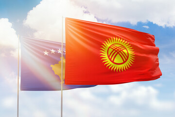 Sunny blue sky and flags of kyrgyzstan and kosovo