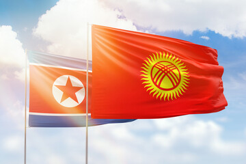 Sunny blue sky and flags of kyrgyzstan and north korea