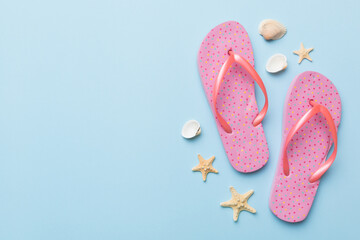 Flat lay composition with flip flops and seashell on colored background. Space for text top view