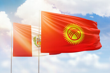 Sunny blue sky and flags of kyrgyzstan and peru