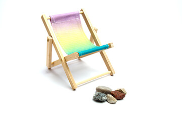 Wooden deckchair sea pebbles on an isolated white background.
