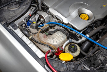 On the valve from the air conditioning system in the car, there is a blue and red quick coupler for...