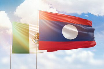 Sunny blue sky and flags of laos and mexico