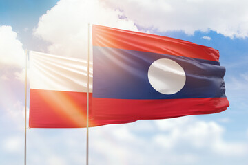 Sunny blue sky and flags of laos and poland