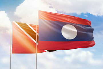 Sunny blue sky and flags of laos and trinidad and tobago